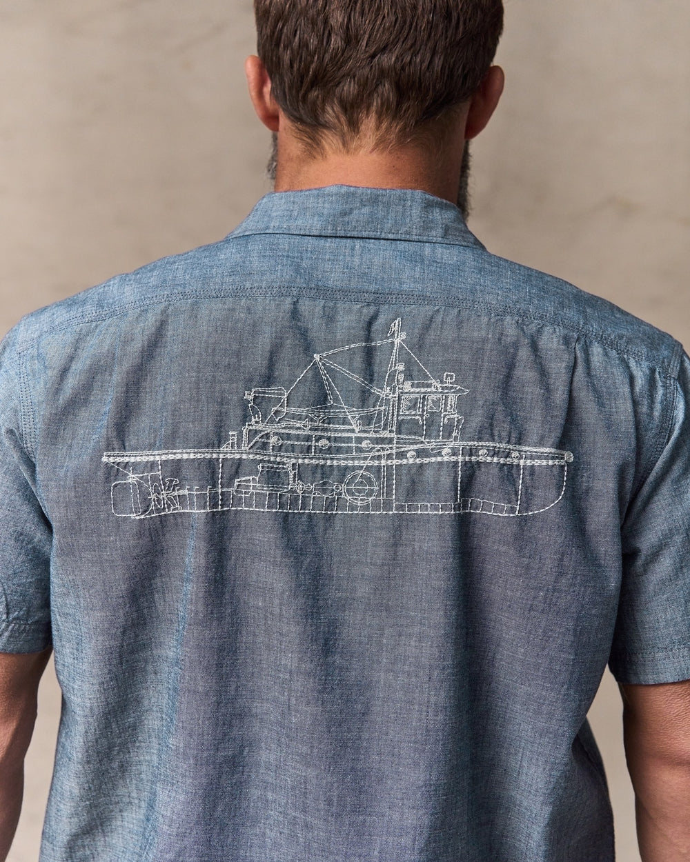 image of a model wearing Filson's Short-sleeve Embroidered Chambray Shirt - Rinsed Indigo