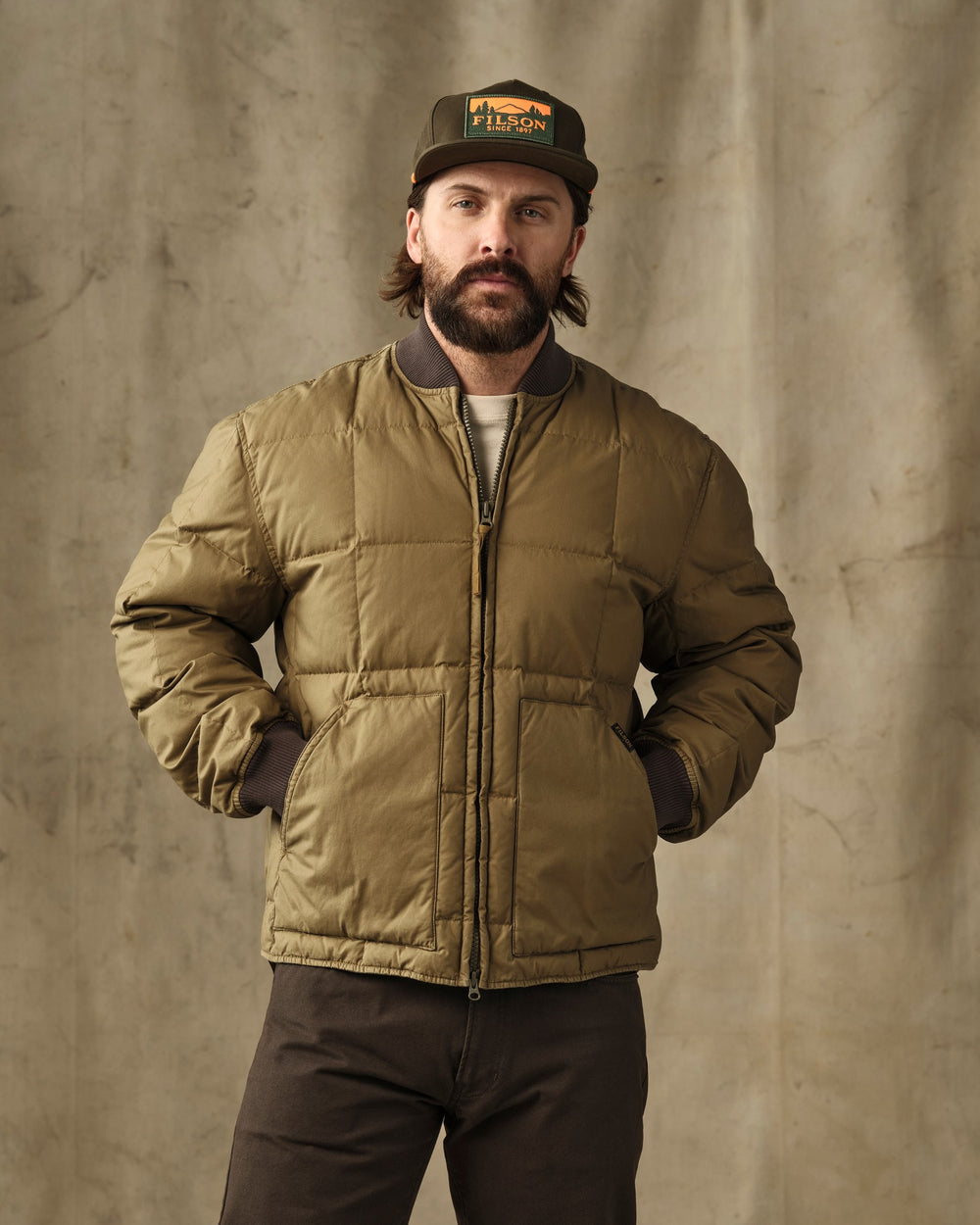 image of a model wearing Filson's Heritage Cotton Down Jacket - Light Brown