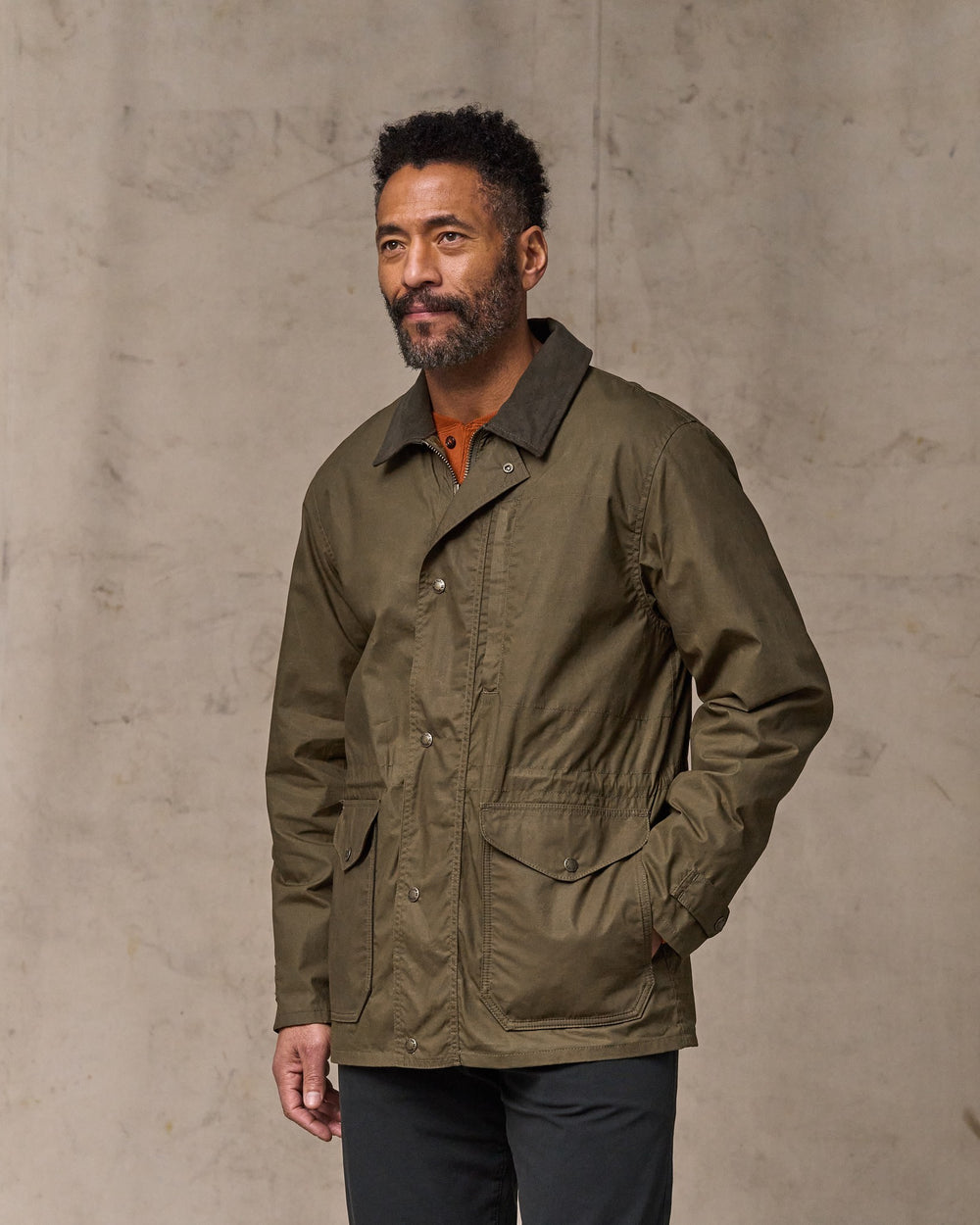 image of a model wearing Filson's Dry Wax Mile Marker Coat - Burnt Olive