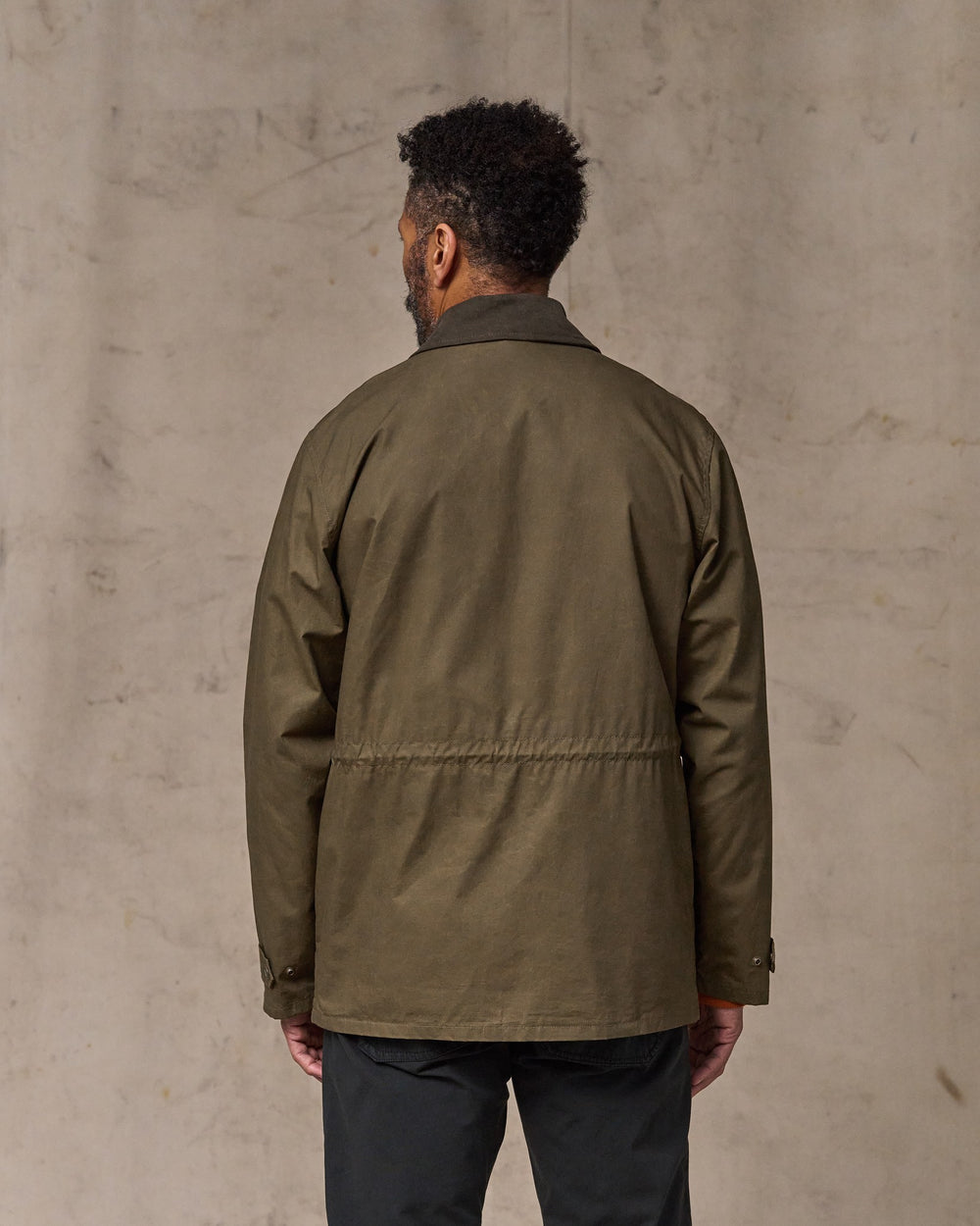 image of a model wearing Filson's Dry Wax Mile Marker Coat - Burnt Olive