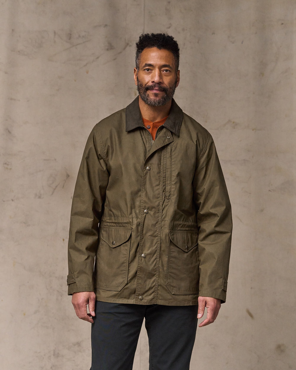 image of a model wearing Filson's Dry Wax Mile Marker Coat - Burnt Olive