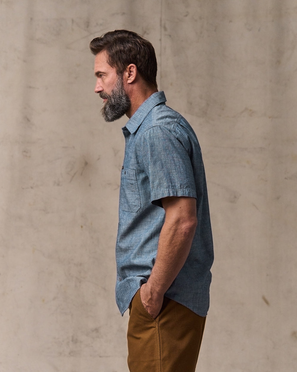 image of a model wearing Filson's Short-sleeve Embroidered Chambray Shirt - Rinsed Indigo