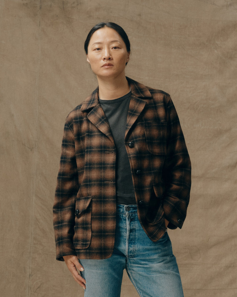 image of a model wearing Filson's Women's Unconstructed Wool Blazer - Bronze Brown Plaid