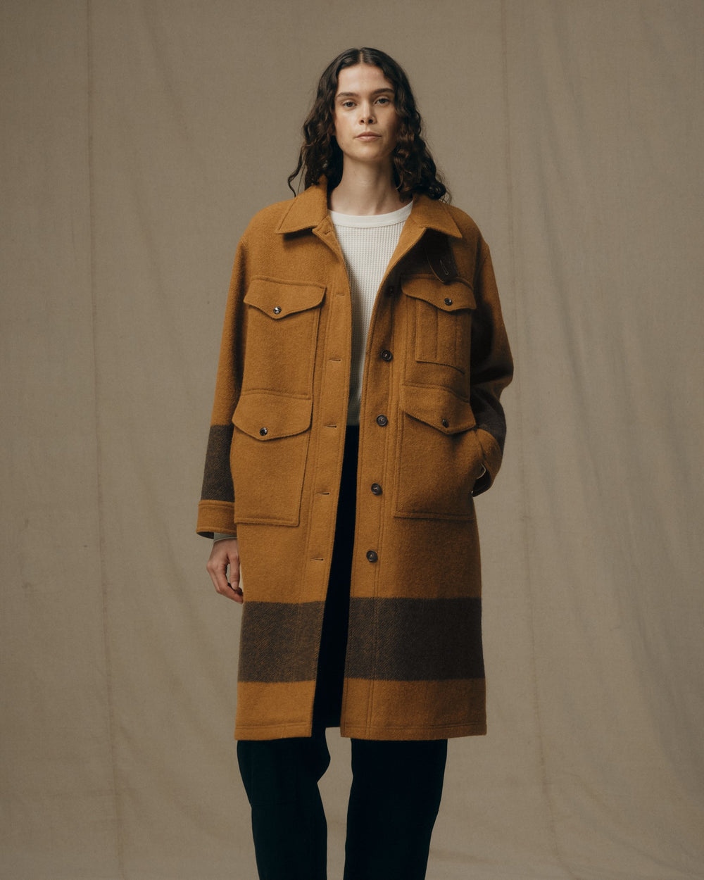 image of a model wearing Filson's Women's Wool Long Cruiser Coat - Whiskey / Black Stripe