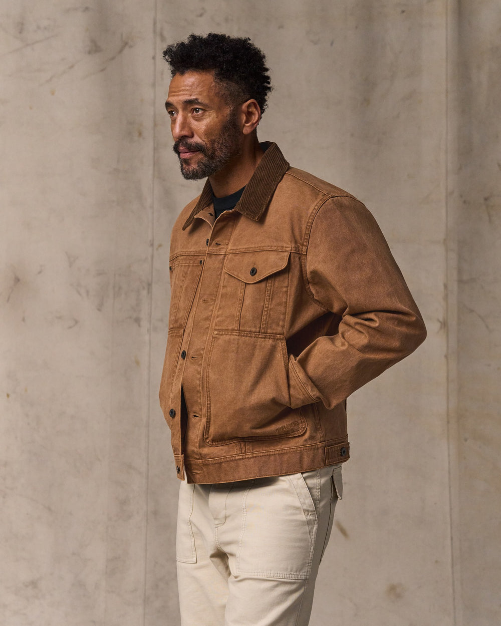 image of a model wearing Filson's Rustic Canvas Short Cruiser Jacket - Whiskey