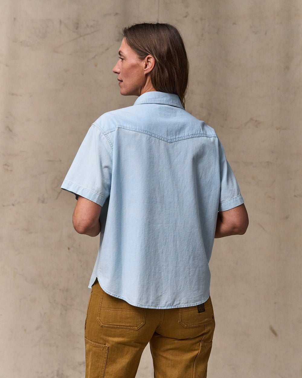 image of a model wearing Filson's Women's Short Sleeve Chambray Western Shirt - Light Indigo